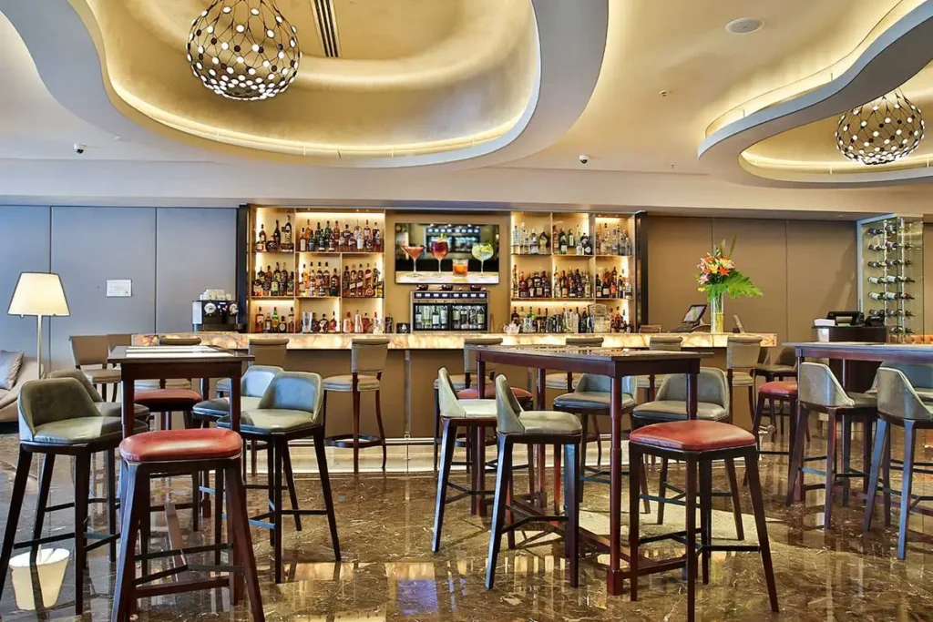 bar élégant du Palladio Hotel Buenos Aires avec comptoir en onyx et luminaires design