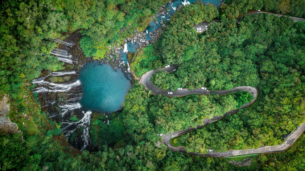 Vue aérienne d'une cascade et route sinueuse dans la forêt réunionnaise