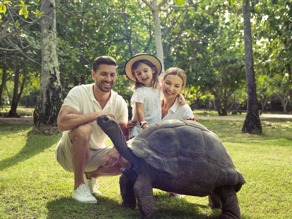 Famille avec une tortue géante d’Aldabra à North Island Seychelles – voyage sur mesure aux Seychelles