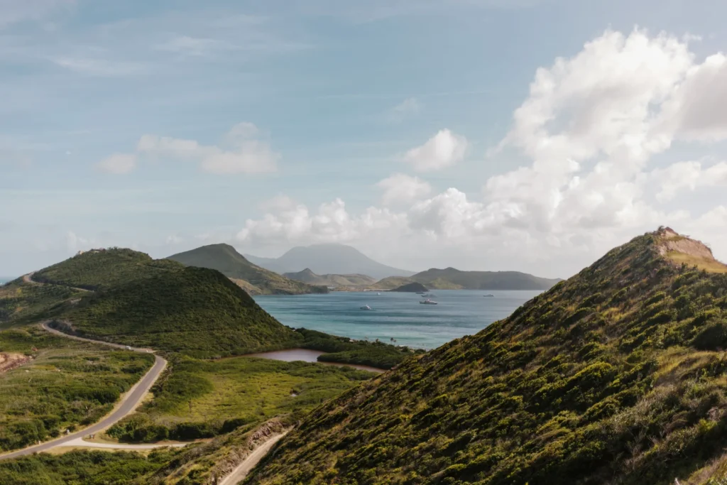 Route sinueuse entre collines vertes et mer lors d'un autotour en Martinique