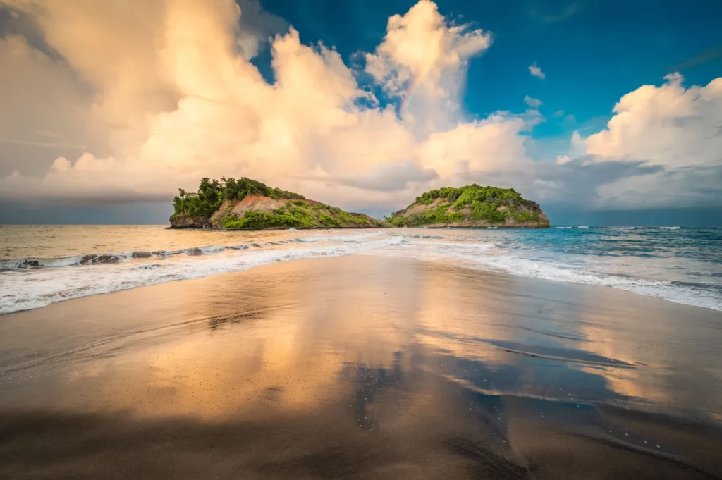 Plage de sable noir du nord de la Martinique sous un ciel dramatique